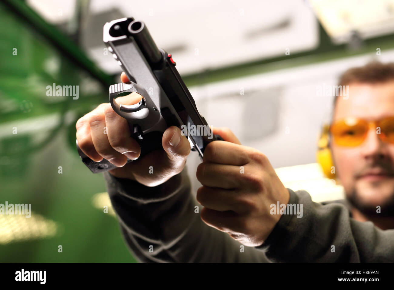 Eine Waffe schießen auf einem Schießstand. Der Mann an den Dreharbeiten lädt Pistole Stockfoto