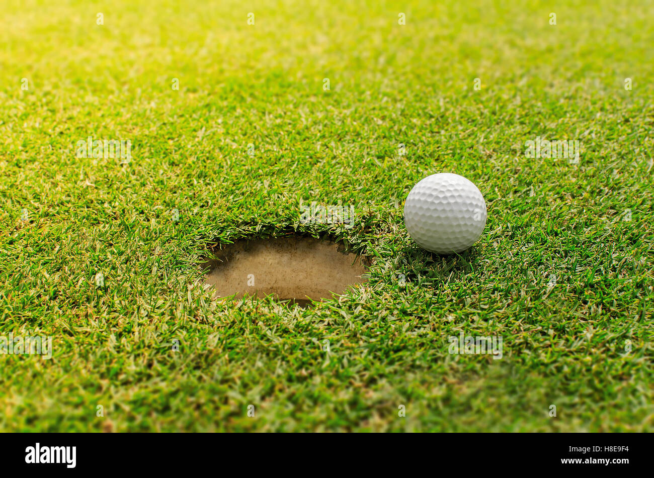 Golf in die Bohrung Stockfoto