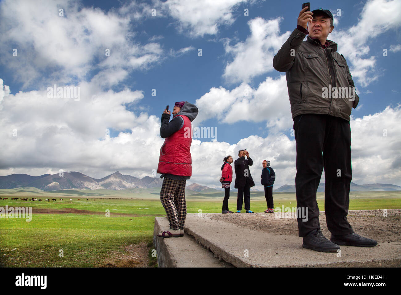 Menschen auf der Suche nach Handy Netzwerk Song Kol See, Kirgisistan Stockfoto