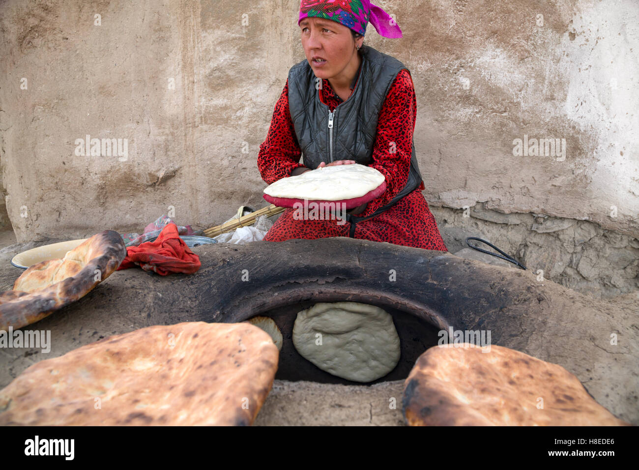 Porträt der Frau, die Herstellung von Brot im Steinofen in Bulunkul Dorf in der Provinz GBAO, Tadschikistan Stockfoto
