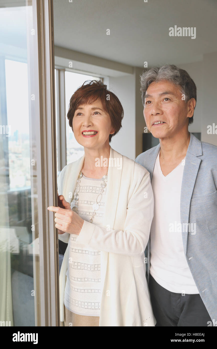 Modische japanische älteres Paar am Fenster Stockfoto