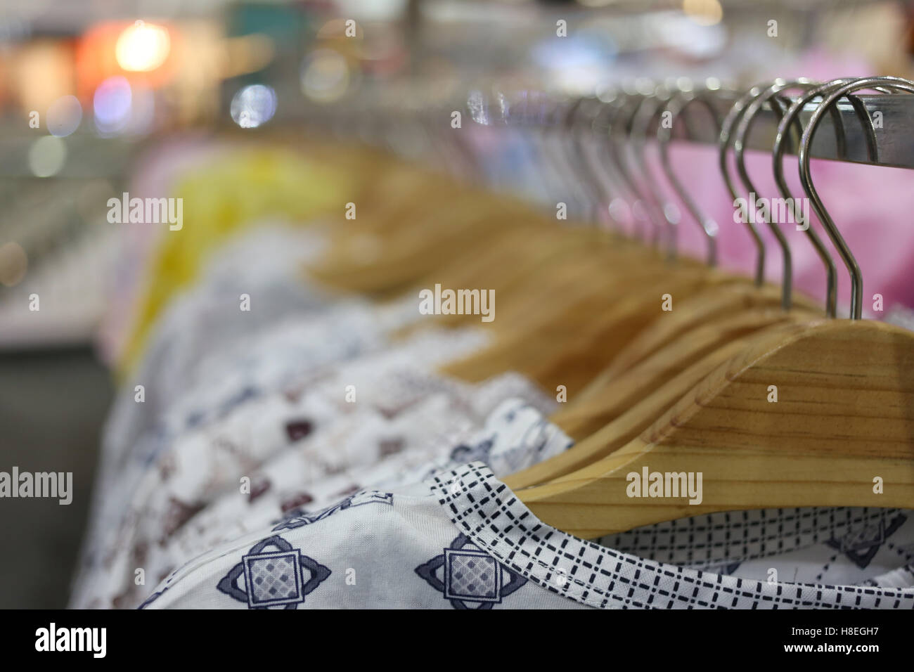 Kleidung hängen auf einem Regal in einem Kaufhaus. Stockfoto