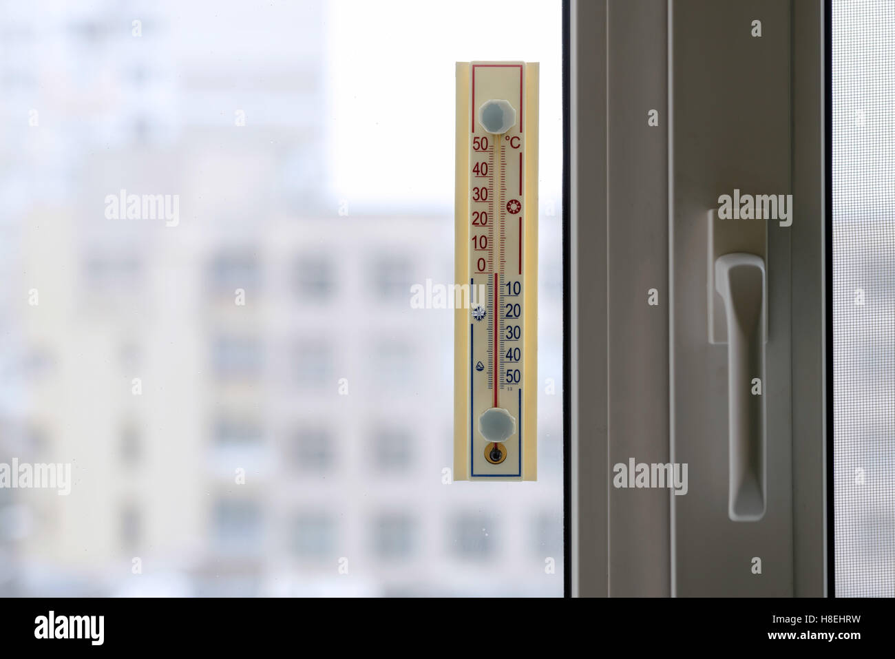 Ein Thermometer, fest aus dem Fenster zeigt, dass es Null Grad Celsius im Freien, solange es warm im Zimmer Stockfoto