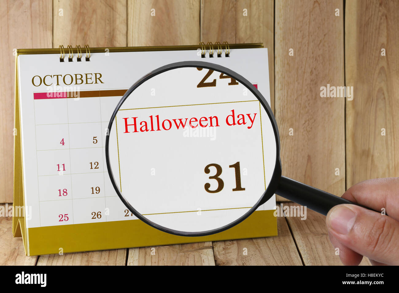 Lupe in der Hand im Kalender sehen Sie Halloween-Tag am 31. Oktober Konzept eines PR-Kampagne-Aktivitäten Stockfoto