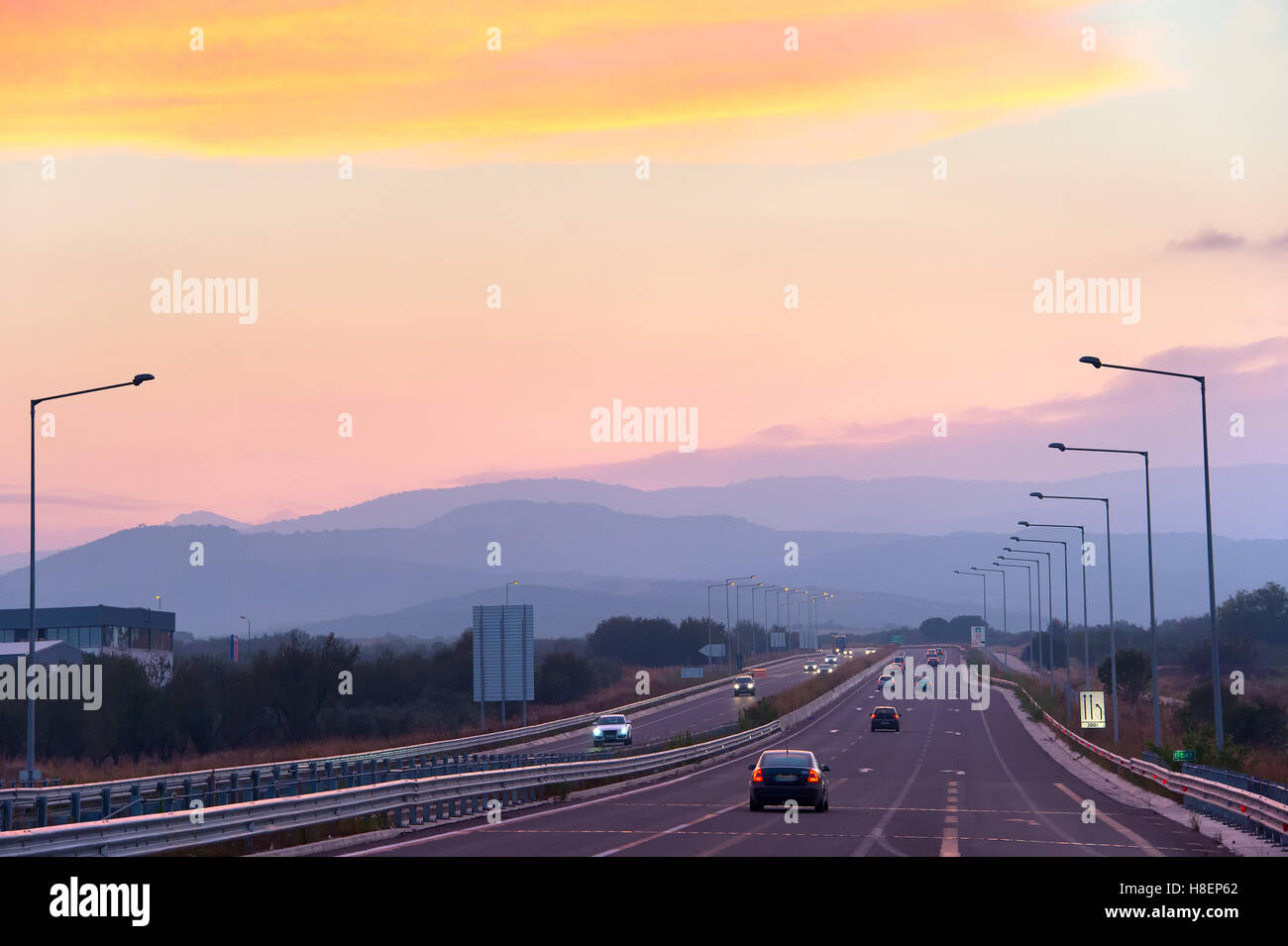 Autos auf der Autobahn in den wunderschönen Sonnenuntergang Stockfoto