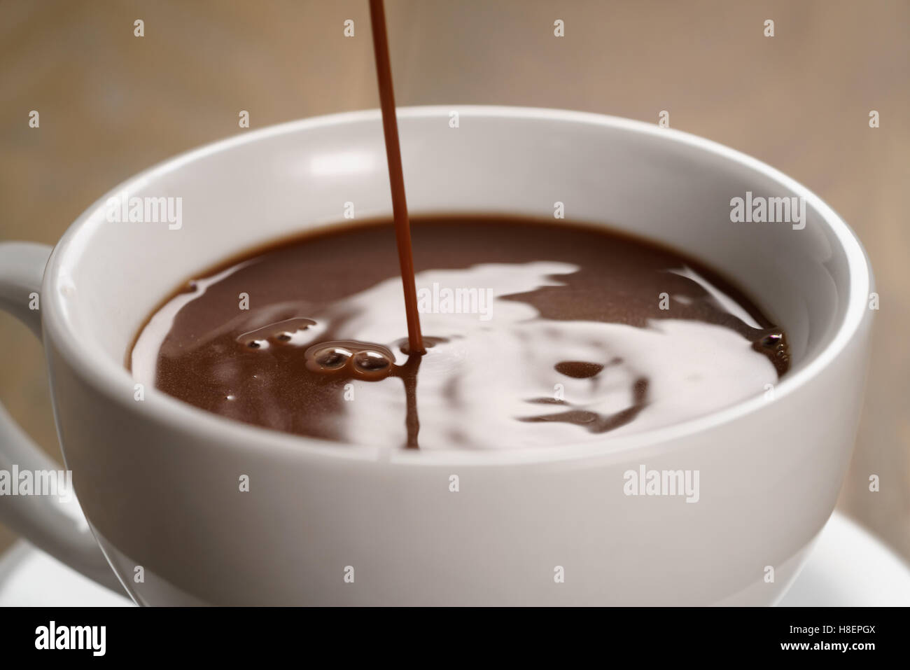 heiße Schokolade gießen in Tasse Stockfoto