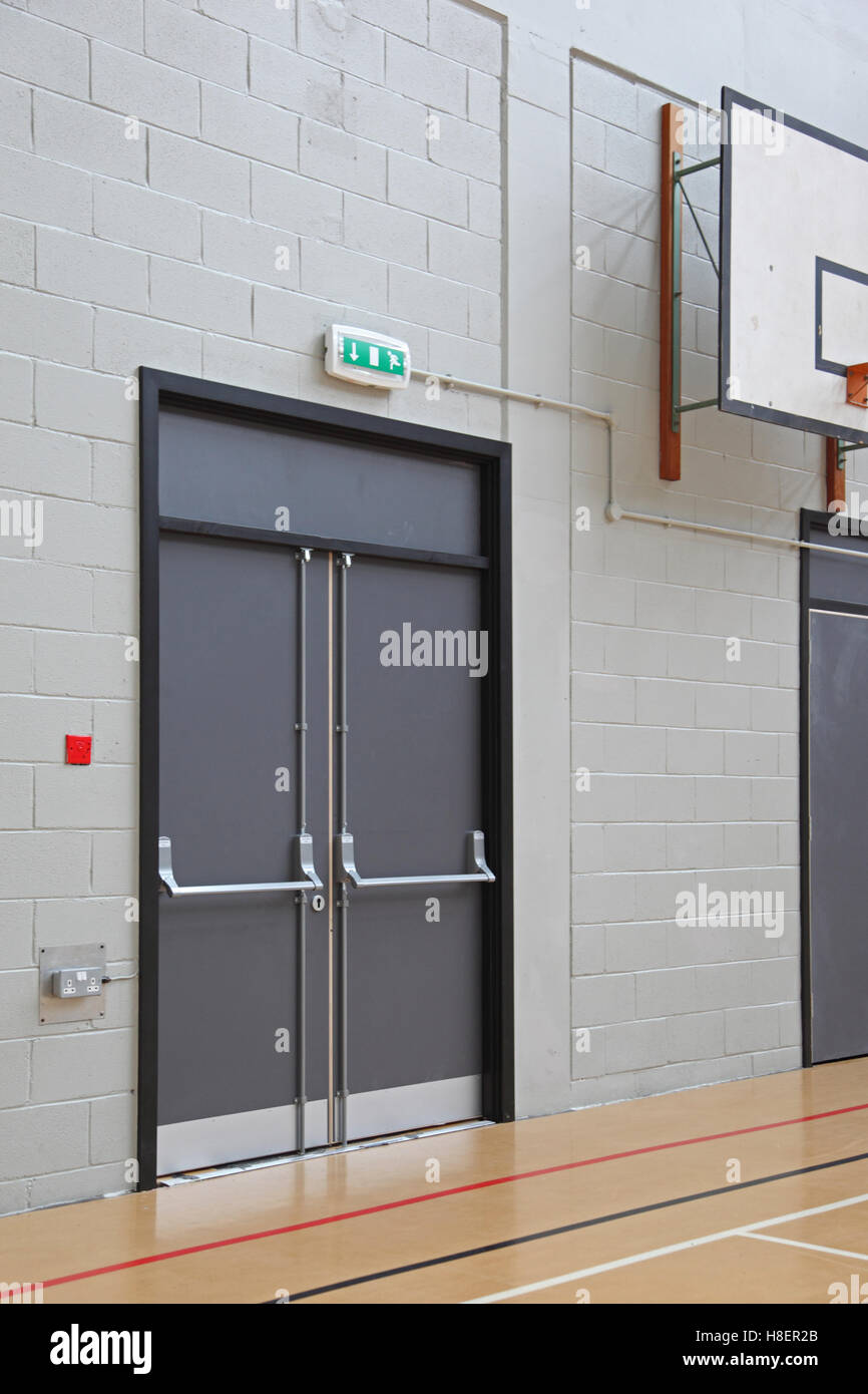 Feuerleiter Tür in der Sporthalle einer modernen London Schule. Zeigt Schiebestange und Panik-Riegel-system Stockfoto