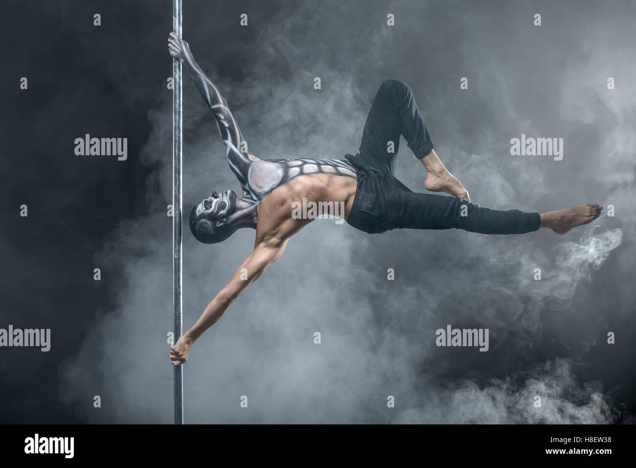 Männliche Pole Tänzerin posiert in dunklen studio Stockfoto