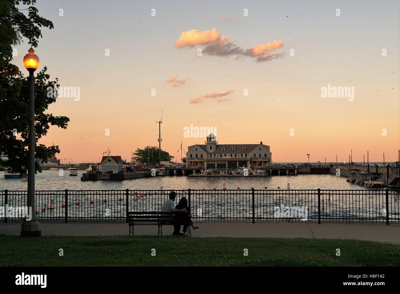 Paar sitzen Sonnenuntergang Chicago Seeverkehrssicherheit Station / Mole Zugang / Marine Pier / Hafen Dusable Stockfoto