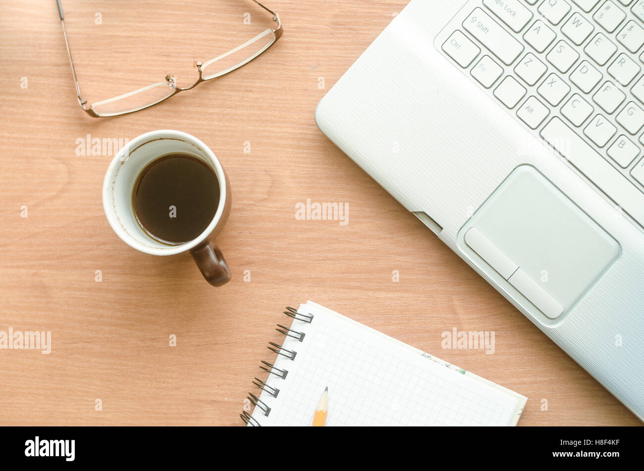 Laptop, Kaffee, Gläser und Notebook auf dem desktop Stockfoto