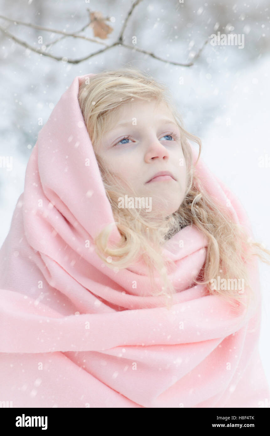 schöne blonde Kind mit rosa Schal im Winter im freien Stockfoto