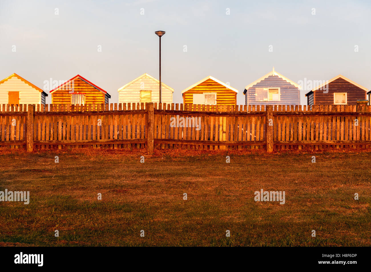 Reihe von bunten Strandhäuschen bei Sonnenuntergang in Southwold, Suffolk, UK Stockfoto