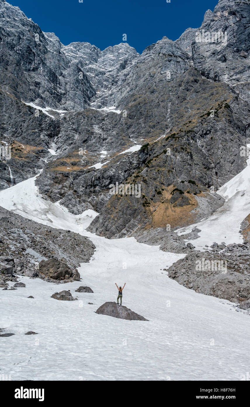 Wanderer auf Felsen mit Arme ausgestreckt, deutschen Alpen tiefsten Schneefeld, Watzmann-Ostwand, Berchtesgaden, Bayern Stockfoto