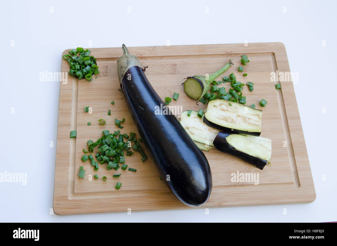 Aubergine mit Frühlingszwiebeln auf Schneidebrett Stockfoto