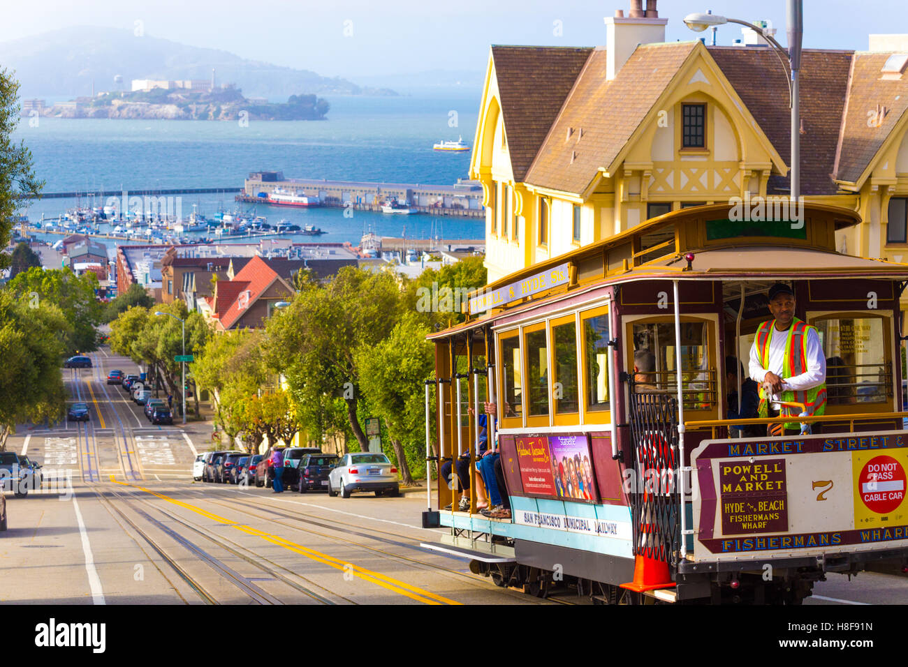 Bremser Appying Seilbahn Bremsen bergab auf einem steilen Hügel der Hyde Street mit herrlichem Blick auf Alcatraz Gefängnis, Bucht Wasser und Stockfoto