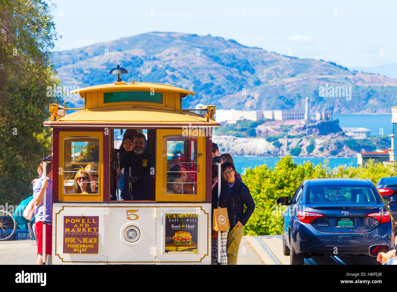 Kultige nahenden Seilbahn voller Touristen an der oberen Spitze der Hyde Street Hill mit Blick auf Alcatraz Insel mit herrlicher natu Stockfoto