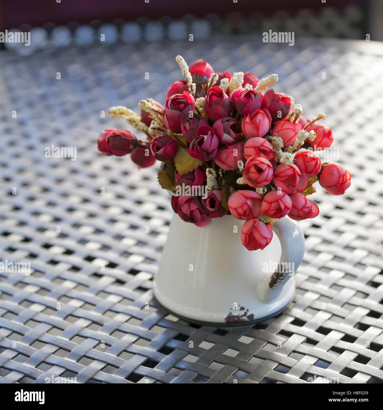 Kunstblumen mit Vase auf Holztisch dekoriert Stockfoto