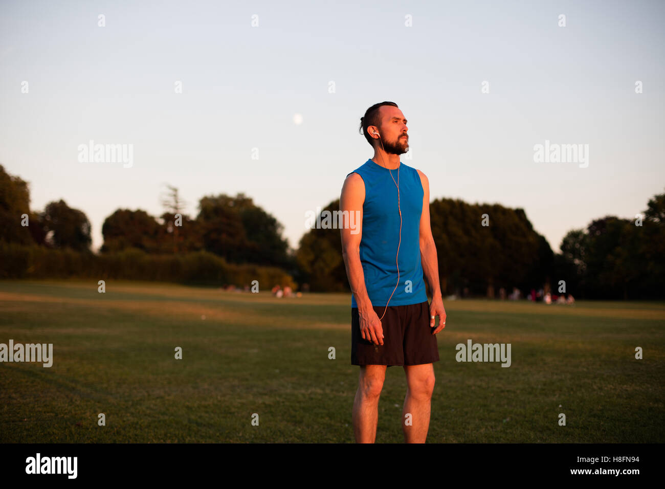 Junger sportlicher Mann, ruhen Sie sich nach einem Lauf im park Stockfoto