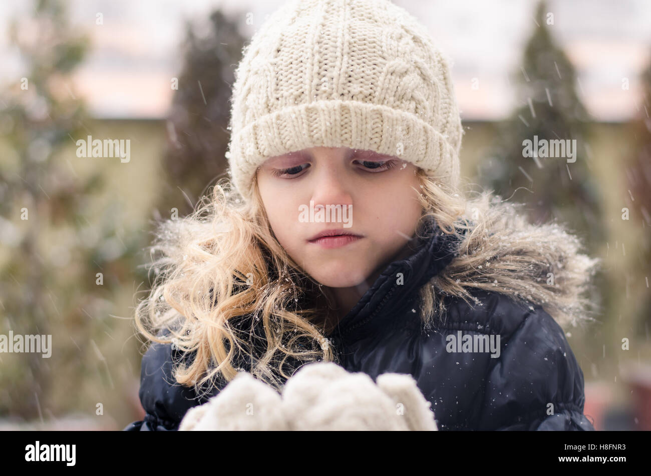 schöne blonde Mädchen spielen mit Schnee Stockfoto
