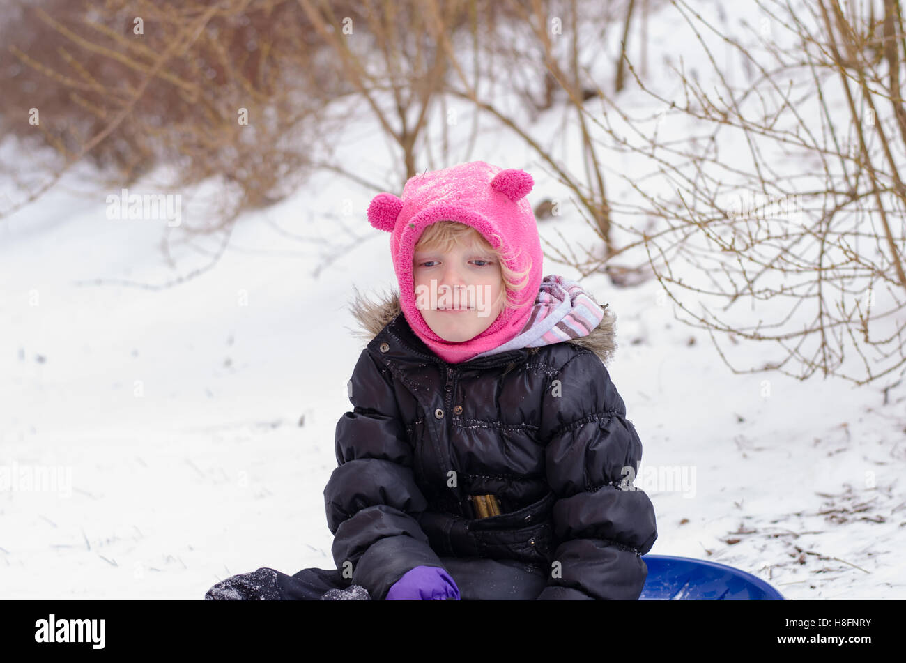 schönes kleines Kind spielen mit Schnee Stockfoto