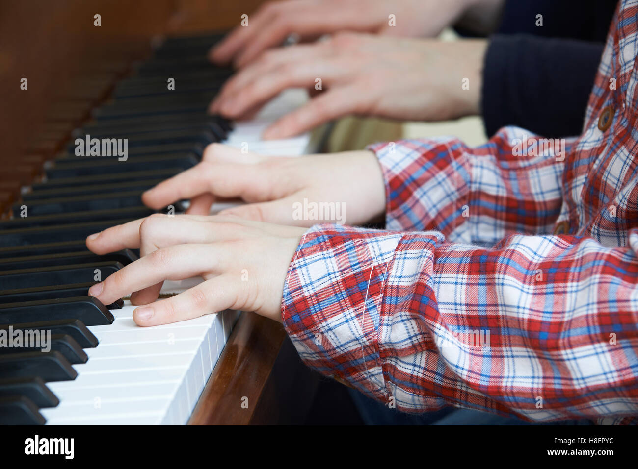Nahaufnahme der junge spielt Klavier zu vier Händen mit Lehrer Stockfoto