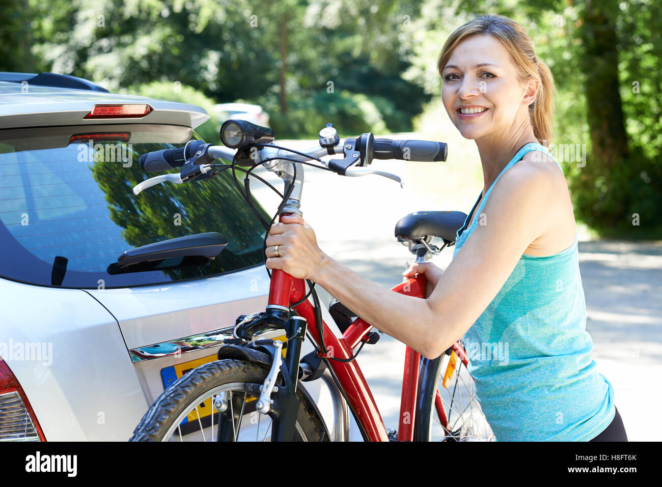 Reife Frau Radfahrer nehmen Mountainbike von Rack auf Auto Stockfoto