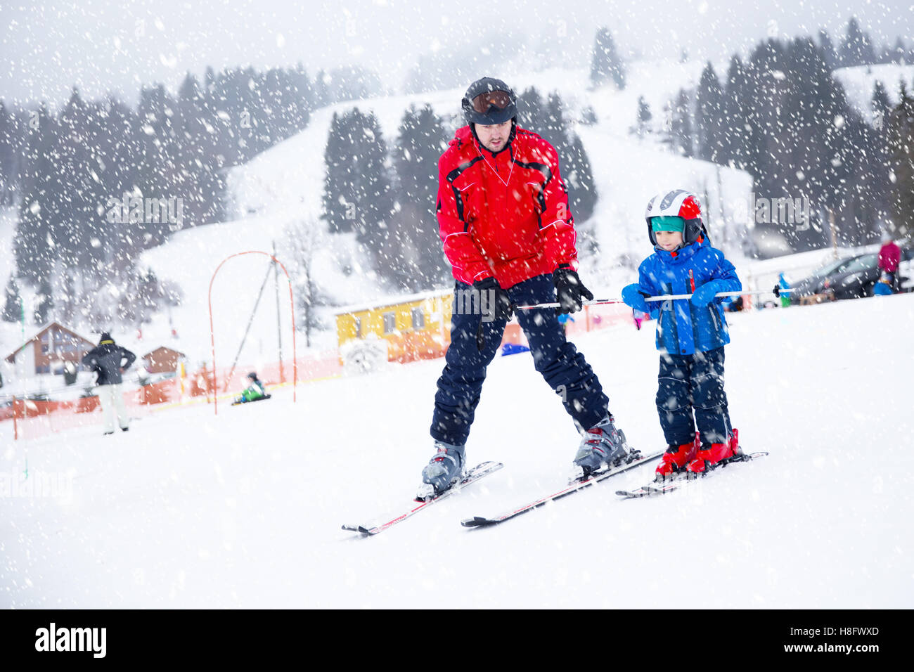 Glücklich kleiner Junge mit seinem Vater während der Winterferien in Schweizer Alpen Skifahren lernen Stockfoto