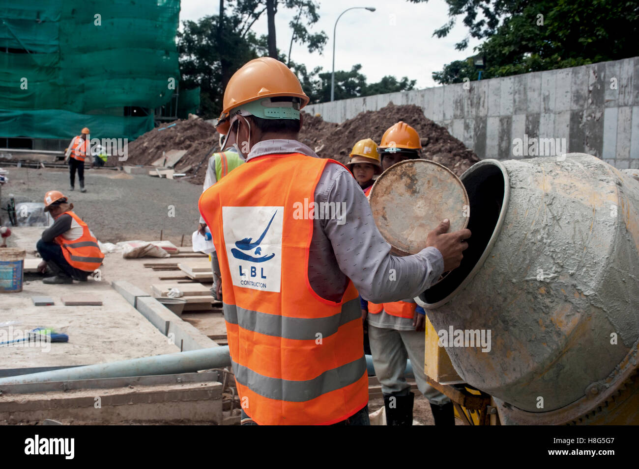 Bauarbeiter benutzen einen Betonmischer auf einer Baustelle in Phnom Penh, Kambodscha. Stockfoto