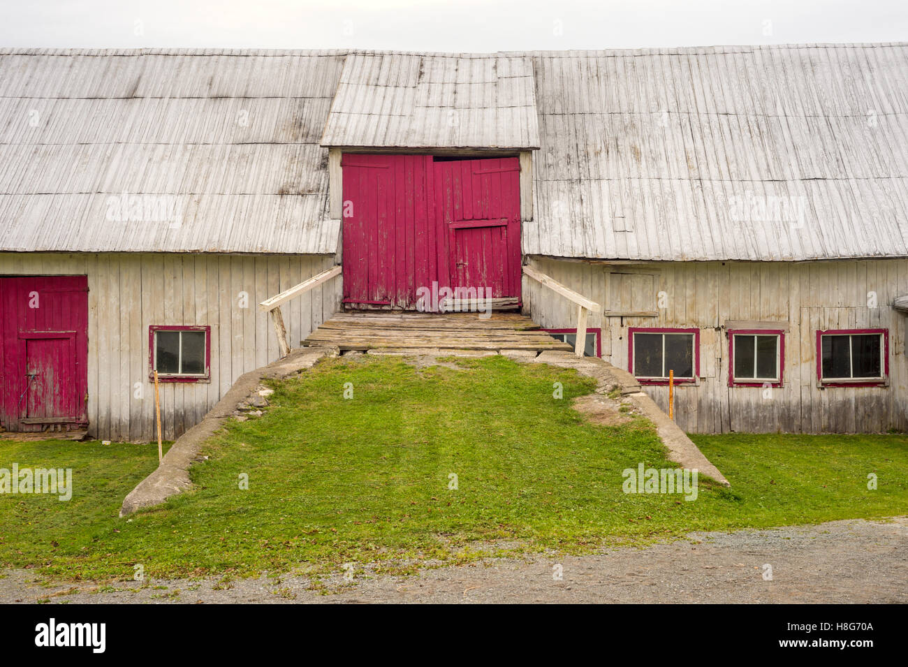 Fassade einer alten Scheune mit roten Türen in Gaspe Peninsila, Provinz Quebec, Kanada Stockfoto