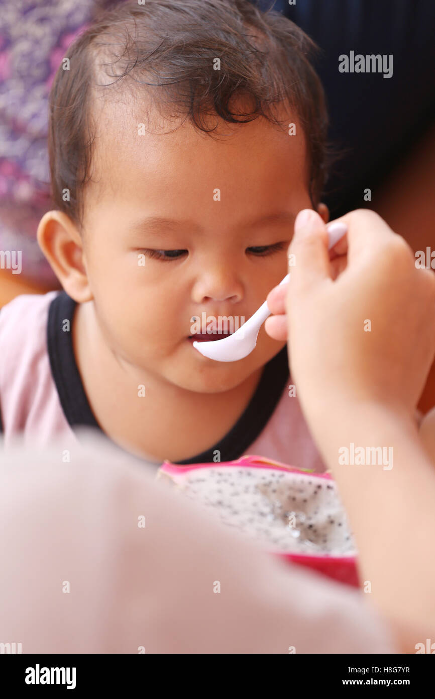Asiatisches Baby Essen eine Drachenfrucht mit glücklich, Konzept von Gesundheit und Lebensmittel für die Kinder. Stockfoto