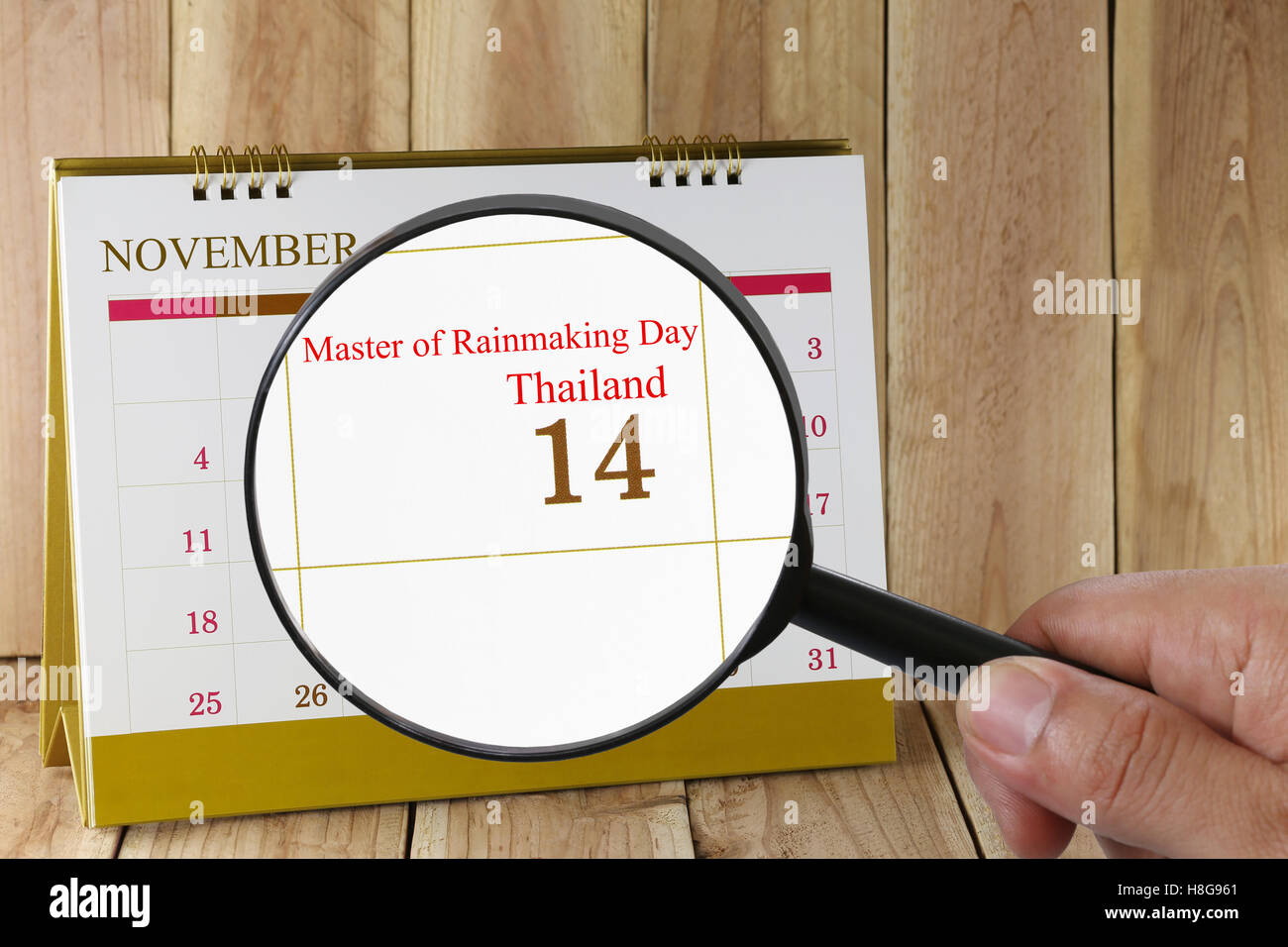 Lupe in der Hand im Kalender sehen Sie Meister der Regenmachen Tag, Thailand am 14. November Konzept einer Public relations Stockfoto
