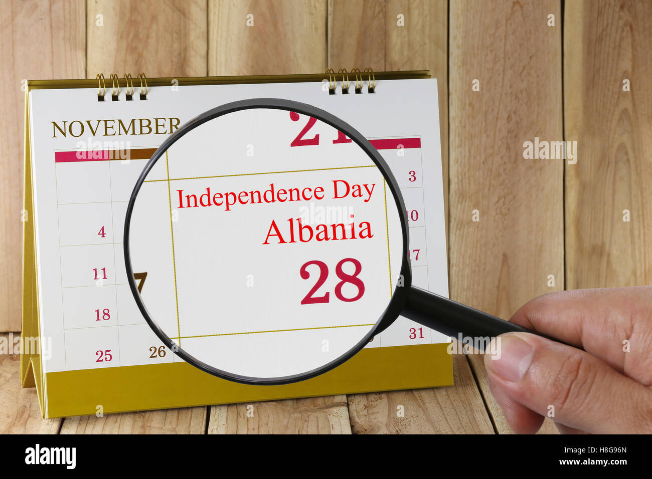 Lupe in der Hand im Kalender sehen Sie Independence Day von Albanien am 28. November Konzept einer Öffentlichkeitsarbeit campa Stockfoto
