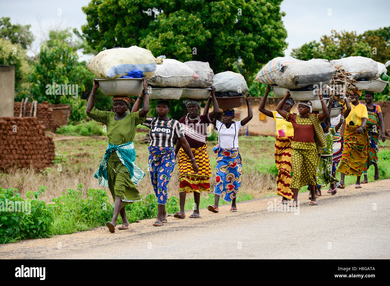 BURKINA FASO, Provinz Poni, Gaoua, Frauen aus den Dörfern tragen Holzkohle und Brennhölzer für Einkommen-Generation auf den Markt in der Stadt Stockfoto