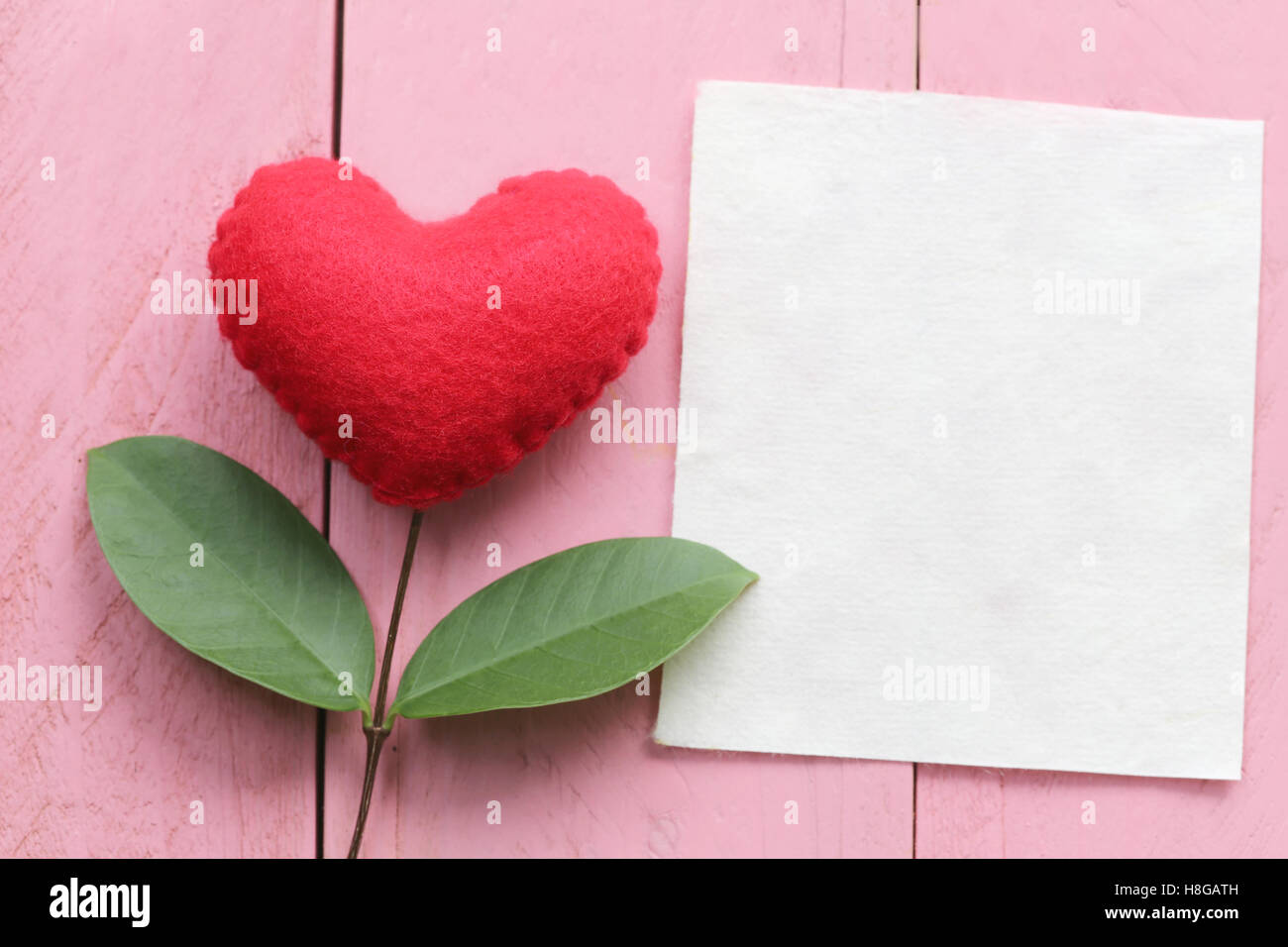 Rotes Herz auf blau Holztisch mit Äste eines Baumes zu verbinden und haben grüne Blätter gelegt, Konzept der Liebe Einfühlungsvermögen kümmern sich um eine Stockfoto