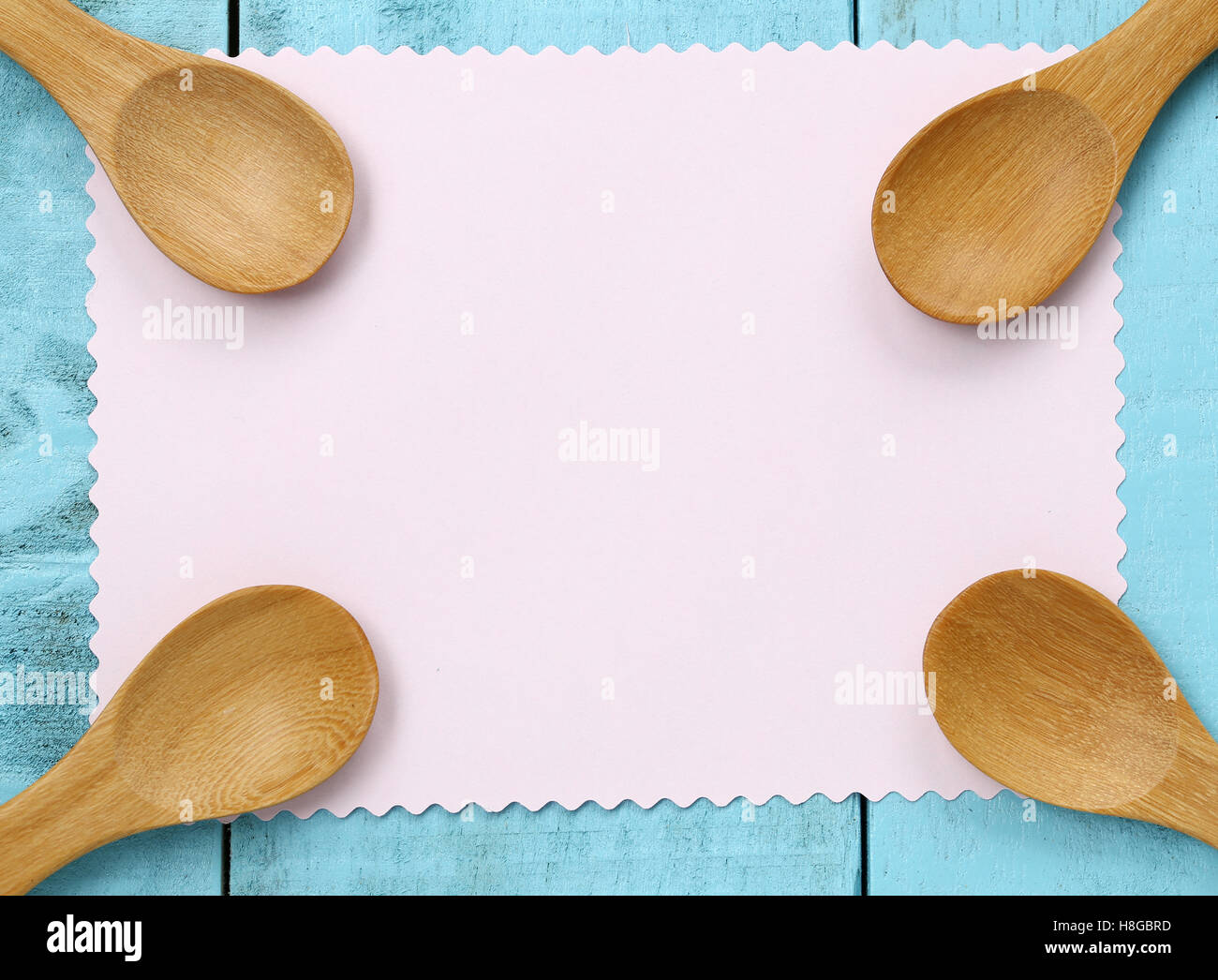 Holzlöffel auf rosa Notizpapier und blauen Holztisch, Konzept von Utensilien und kochen. Stockfoto