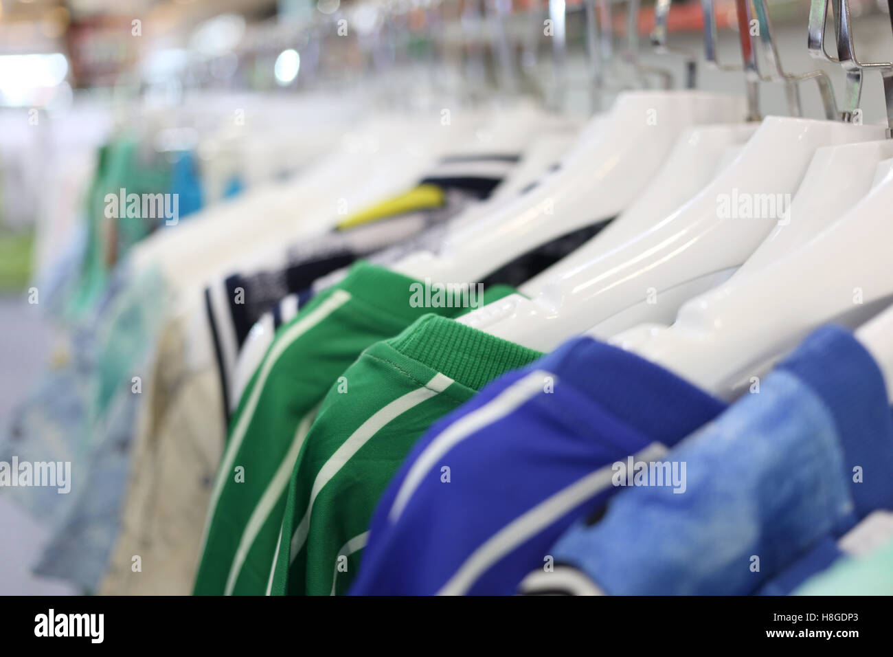 Kleidung hängen auf einem Regal in einem Kaufhaus. Stockfoto