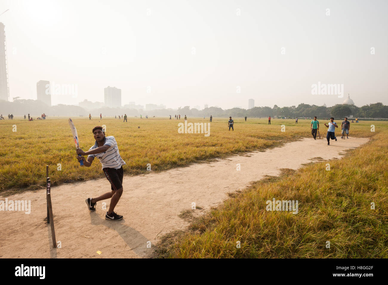 Junge Männer spielen Cricket auf dem Maidan in Kolkata (Kalkutta), Indien Stockfoto