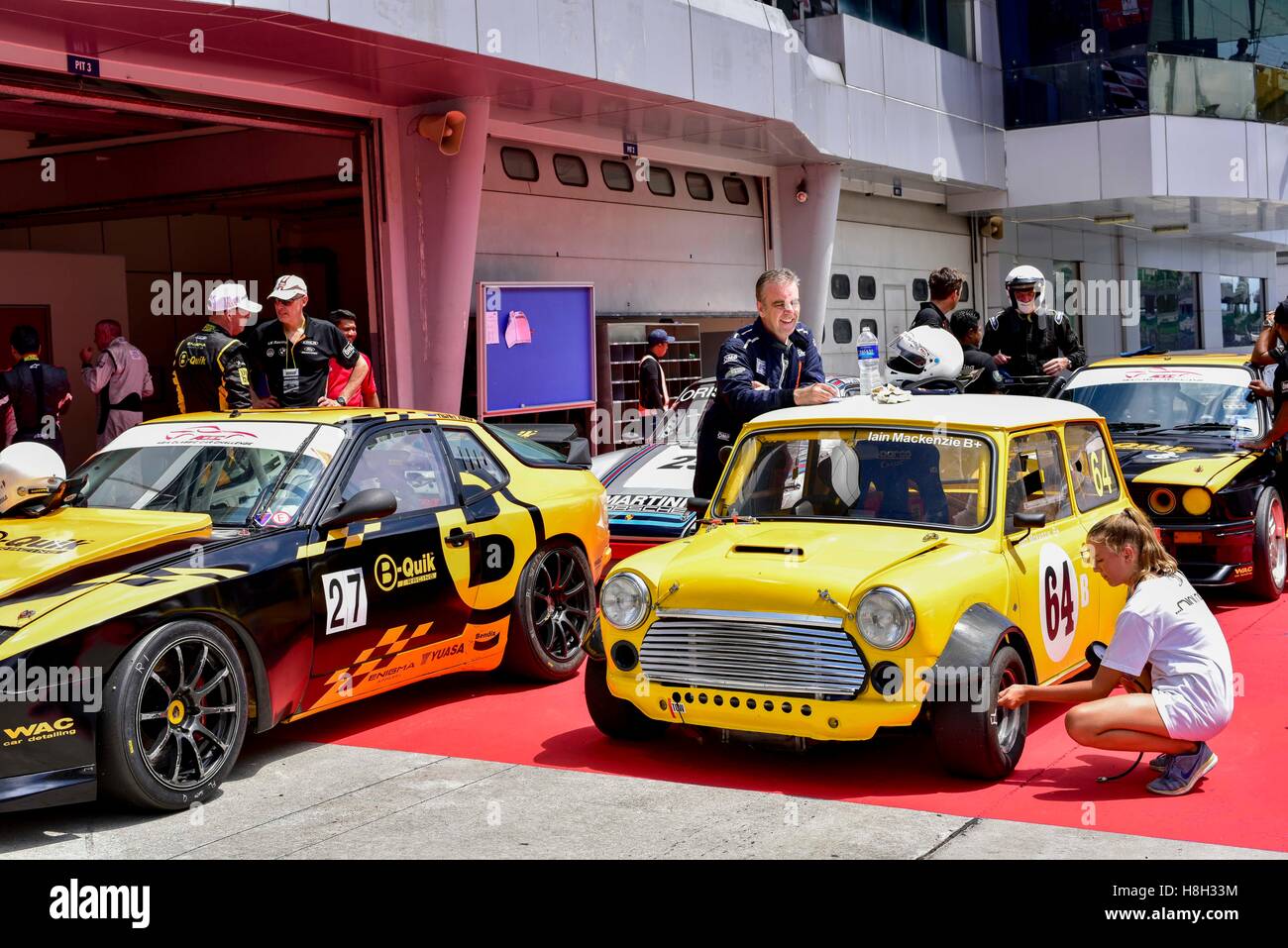 Iain Mackenzie(center) Auto Crew Teammitglied überprüft die Reifen auf der Koppel nach der Asien Classic Car Challenge in Sepang Circuit am 12. November 2016 in Kuala Lumpur, Malaysia. Stockfoto