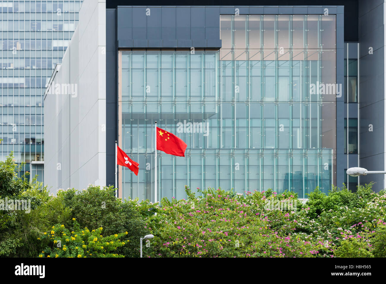 Chinesische Flagge und Hong Kong Fahne flattert vor Hong Kong Chief Executive Office in Admiralty, Hong Kong Stockfoto