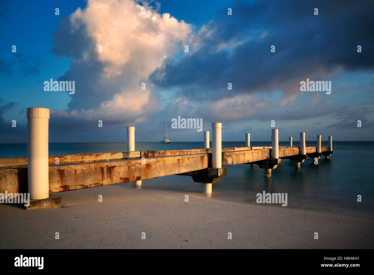 Pier und Sonnenaufgang mit Boot. Turks- und Caicosinseln. Providenciales Stockfoto
