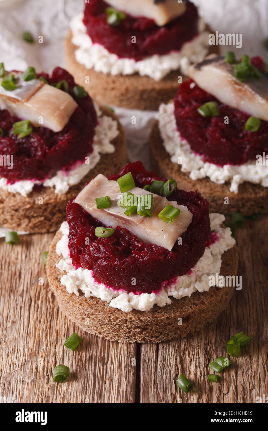 Norwegische Sandwiches mit Hering, rote Beete und Frischkäse auf einem Tisch-Makro. vertikale Stockfoto