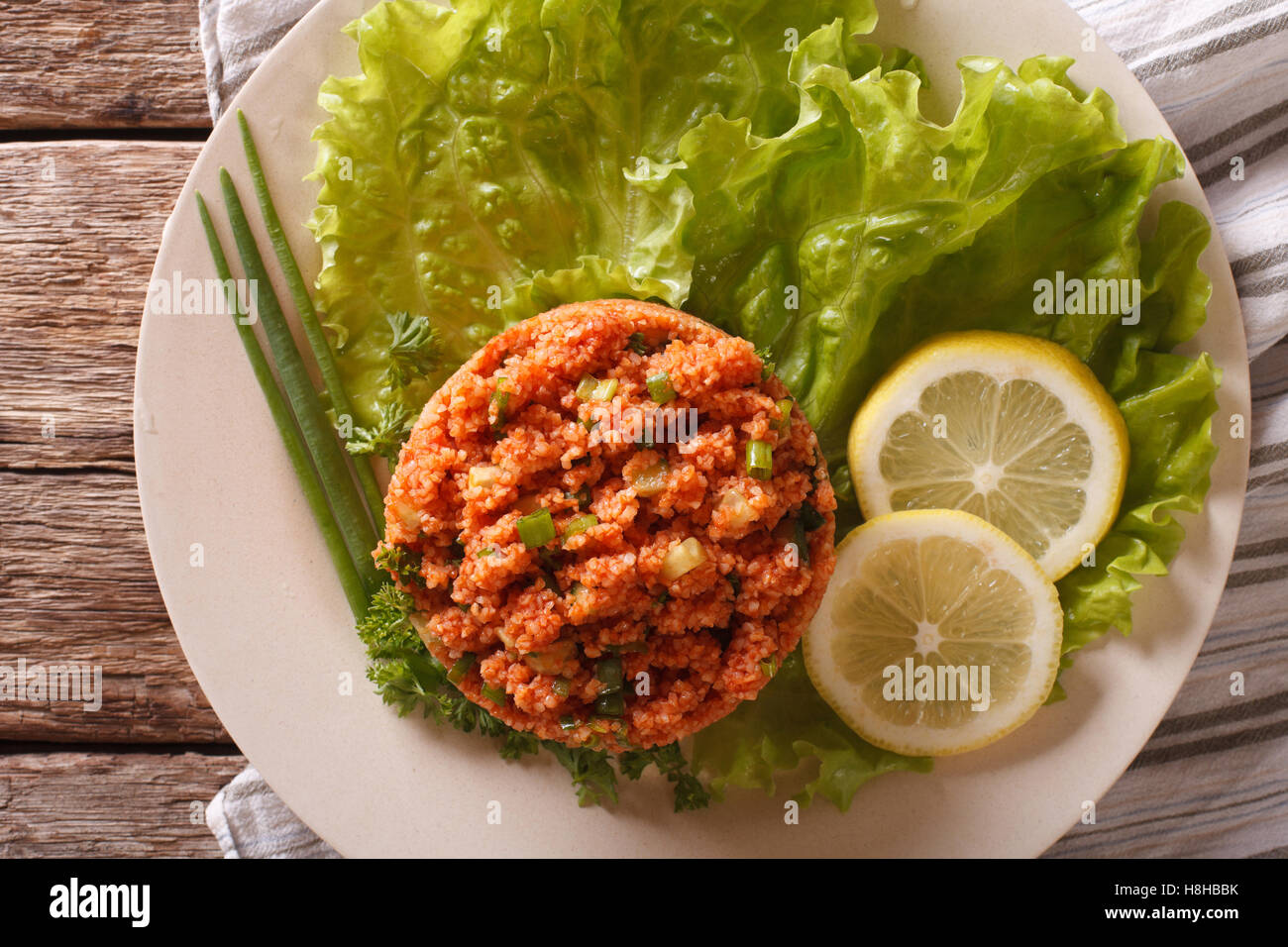 Traditionelle türkische Bulgur Salat Kisir close-up auf einem Teller auf den Tisch. Horizontale Ansicht von oben Stockfoto