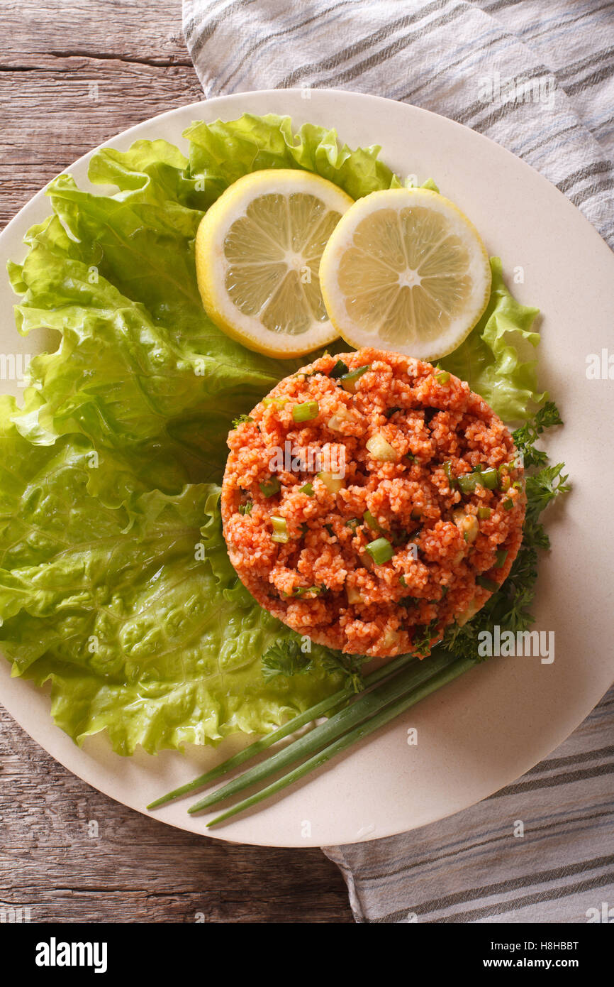 Traditionelle türkische Bulgur Salat Kisir close-up auf einem Teller auf den Tisch. Vertikale Ansicht von oben Stockfoto