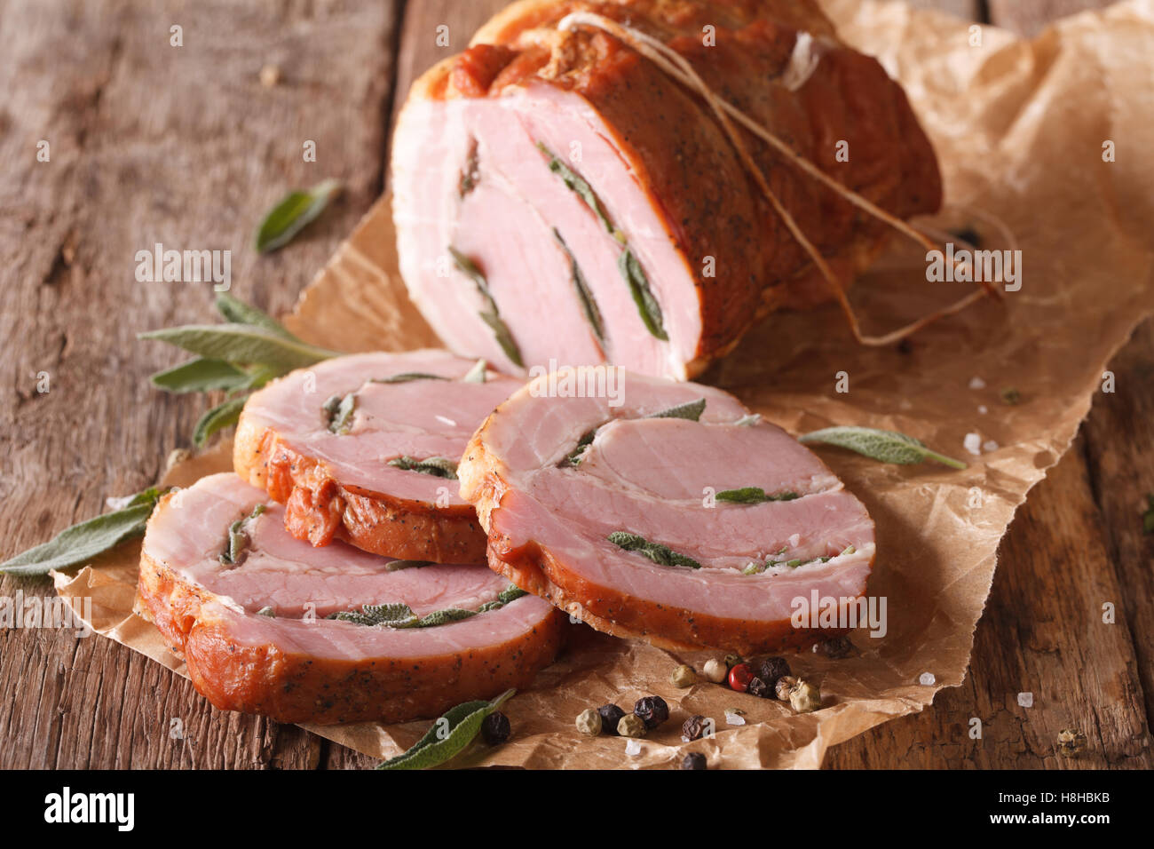 Gebackene Roll vom Schwein gefüllt mit Salbei hautnah auf dem Tisch. horizontale Stockfoto