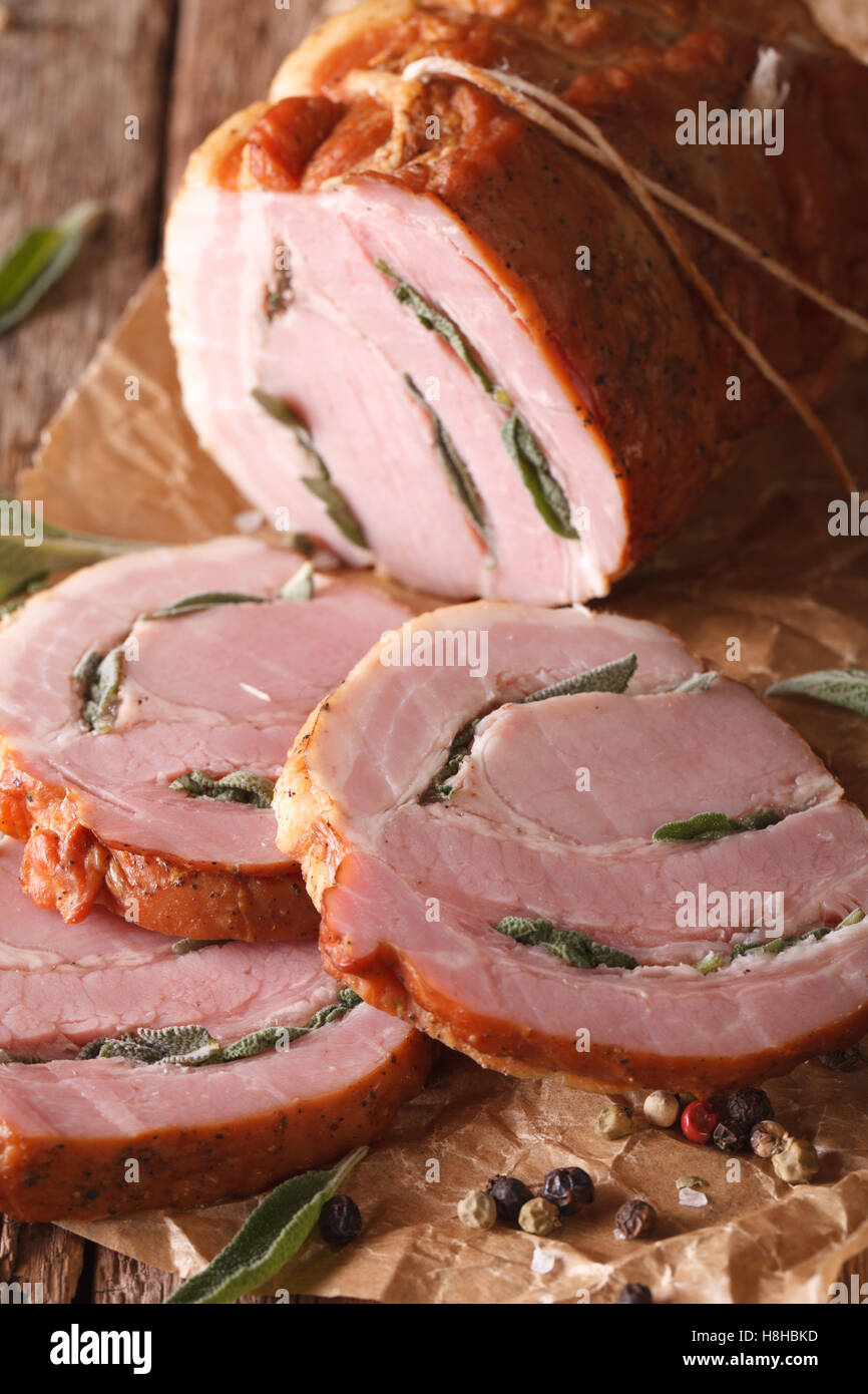 Gebackenes Schweinefleisch gefüllt mit Salbei hautnah auf dem Tisch. vertikal, rustikal Stockfoto