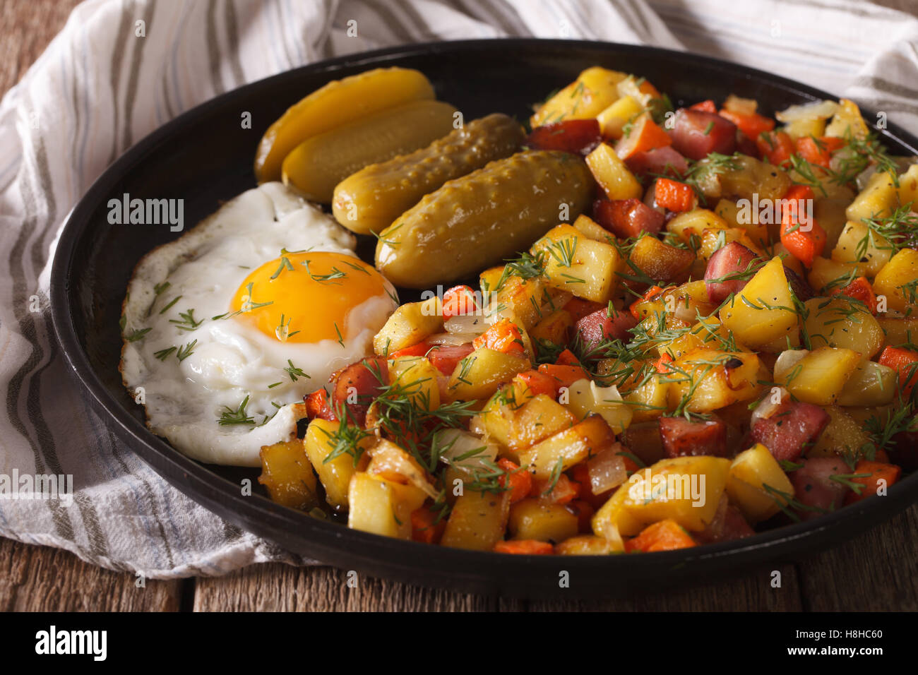 Skandinavische Bratkartoffeln mit Würstchen, Eiern und Gurken ...