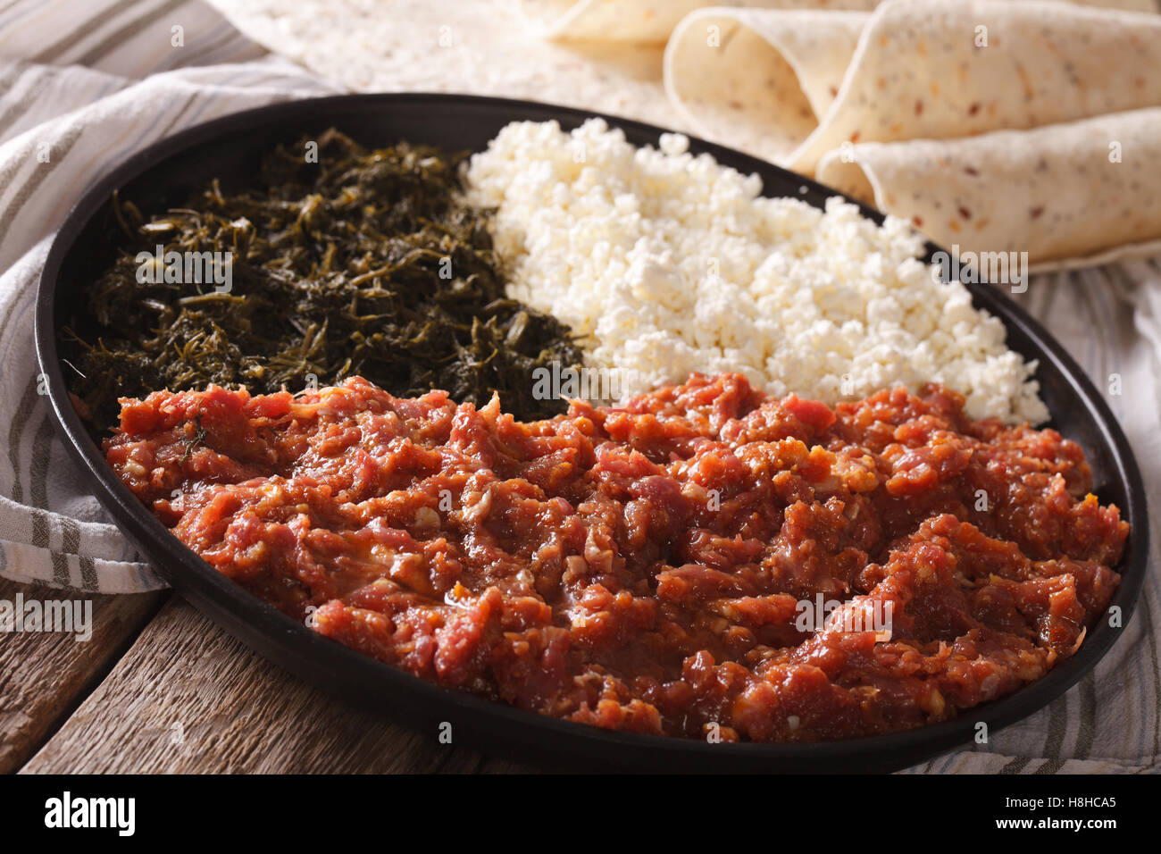 Äthiopische Küche: Kitfo mit Kräutern und Käse auf einen Teller und Injera. Horizontale Stockfoto