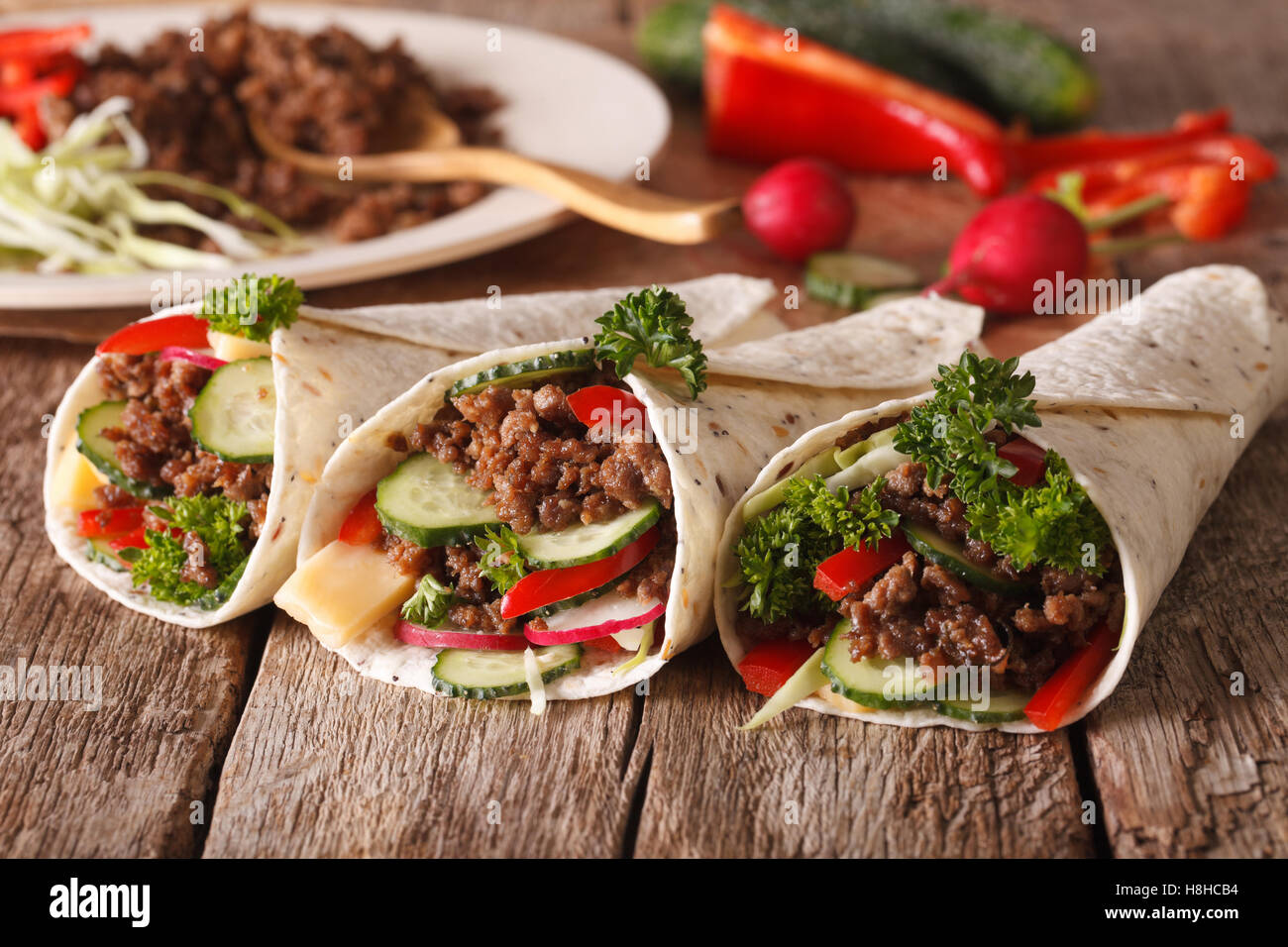 Tortilla mit Rindfleisch und Gemüse Nahaufnahme und Zutaten auf dem Tisch Rollen. horizontale Stockfoto