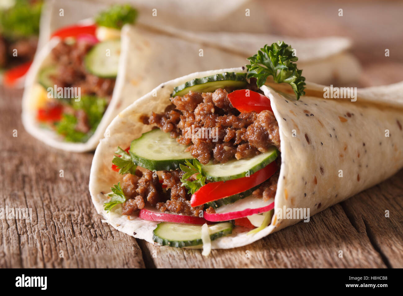 Sandwich-Rollen mit Rindfleisch und frischem Gemüse Makro auf dem Tisch. Horizontale Stockfoto