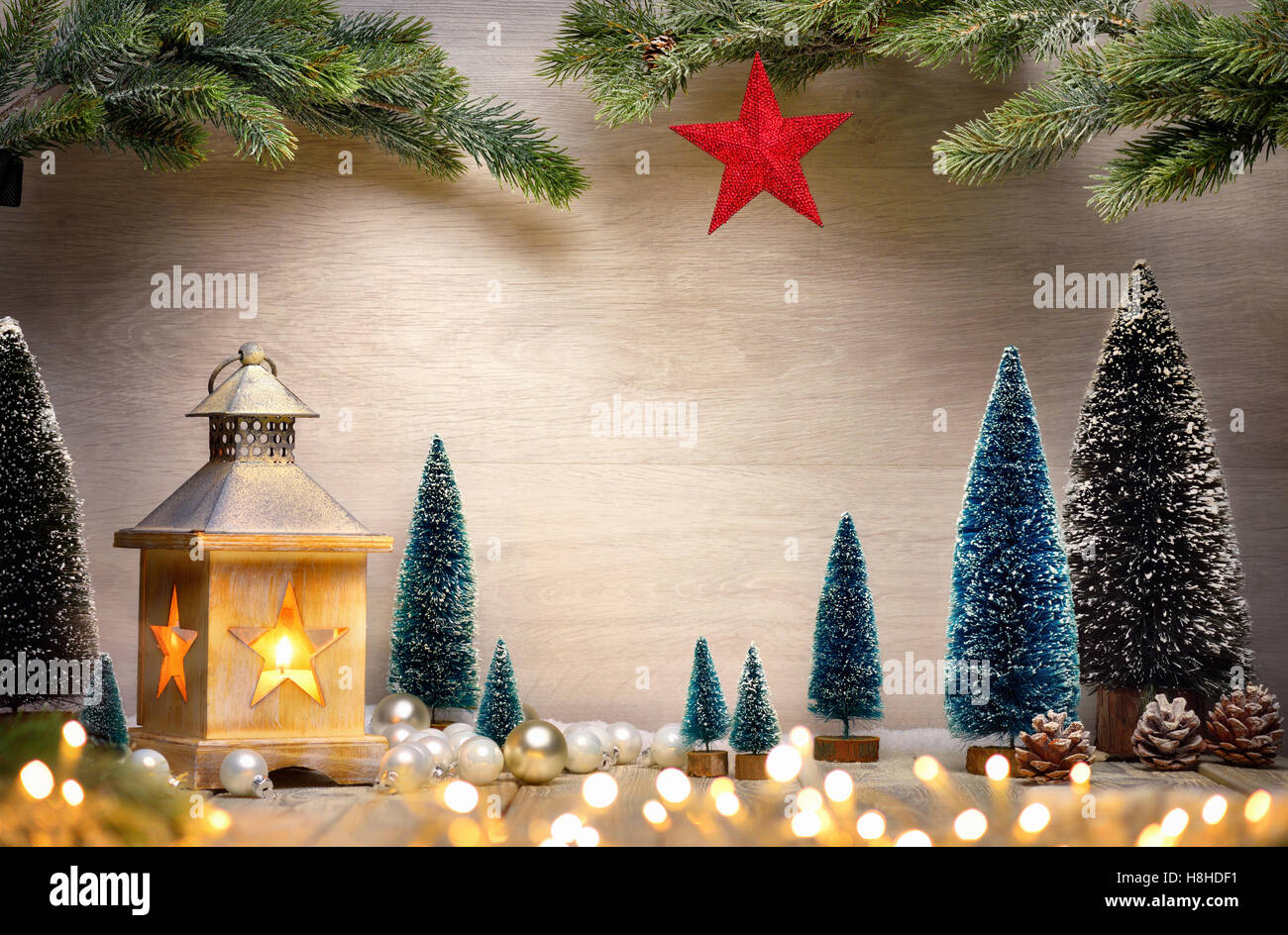 Weihnachten Hintergrund der Szene mit einer Laterne, Bäume, Tannenzweigen, roter Stern und unscharfen Lichter vor einem Holzbrett als Kopie s Stockfoto